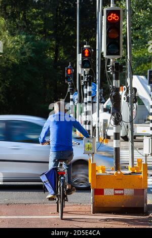 Cycliste attendant le feu rouge d'un feu de circulation temporaire En raison des travaux routiers à Rotterdam aux pays-Bas Banque D'Images