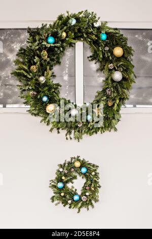 Deux couronnes de fête vertes en épicéa frais, décorées de jouets du nouvel an, guirlandes. Décoration de Noël. Suspendu au-dessus d'une cheminée Banque D'Images