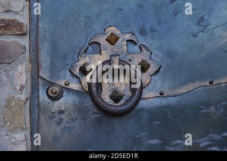 La poignée ronde d'une ancienne porte rouillée de fer forgé dans une forteresse médiévale de Sudak. Gros plan. Banque D'Images