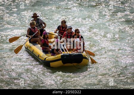 Rafting en eau vive, un groupe de personnes, enfants et adultes, avec un instructeur sur un radeau pneumatique dans la rivière Adige dans le centre-ville de Vérone, Italie. Banque D'Images