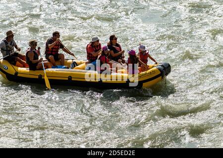 Rafting en eau vive, un groupe de personnes, enfants et adultes, avec un instructeur sur un radeau pneumatique dans la rivière Adige dans le centre-ville de Vérone, Italie. Banque D'Images