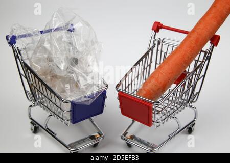 Vue sur deux chariots isolés avec un seul isolé carotte et trop de déchets d'emballage en plastique Banque D'Images