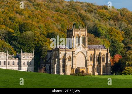 Milton Abbas, Dorset, Royaume-Uni. 13 octobre 2020. Météo Royaume-Uni. Les arbres boisés sont dans leurs couleurs d'automne derrière l'abbaye historique de Milton à Milton Abbas à Dorset, lors d'une après-midi de chaudes périodes ensoleillées. Crédit photo : Graham Hunt/Alamy Live News Banque D'Images