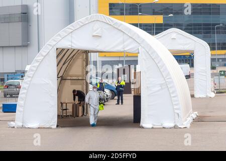 Paramédic portant un équipement de protection désinfectant une tente de station d'essai mobile pour les voitures pendant l'épidémie de coronavirus ou de COVID19, point d'accès médical Banque D'Images