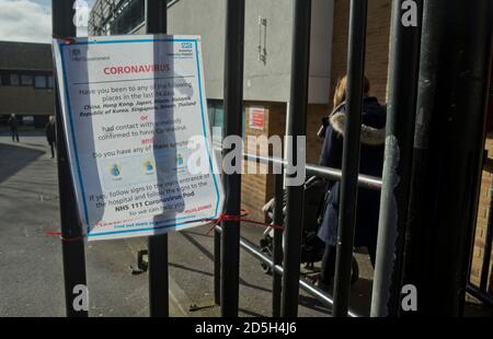 Les visiteurs se promeussent devant les panneaux d'avertissement du coronavirus à l'hôpital Homerton NHS de Londres, en Angleterre, au Royaume-Uni Banque D'Images