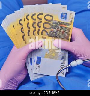 Le médecin tient des billets en euros entre ses mains. Une infirmière féminine avec de l'argent pour acheter des médicaments pour le coronavirus Banque D'Images