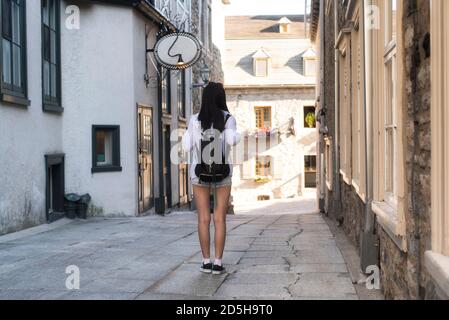 Une chinoise qui descend une ruelle étroite près de la place paris dans le vieux port de Québec, Canada. Banque D'Images