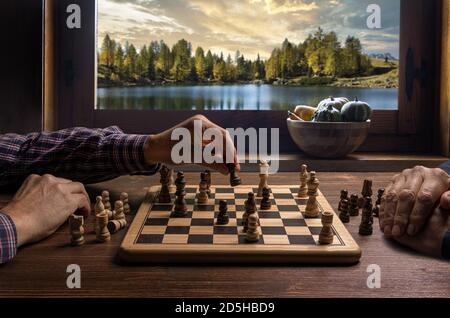 jouer aux échecs devant la fenêtre avec l'automne paysage en arrière-plan Banque D'Images