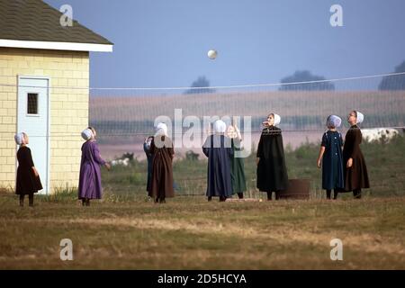 Les filles de l'école Amish jouent au volley-ball dans une cour d'école - Shipshewana - Indiana Banque D'Images