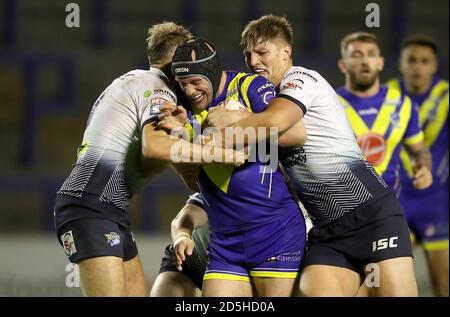 Le Chris Hill (au centre) de Warrington Wolves est abordé par Sam Walters (à gauche) de Leeds Rhinos et James Harrison lors du match de la Super League de Betfred au stade Halliwell Jones, à Warrington. Banque D'Images