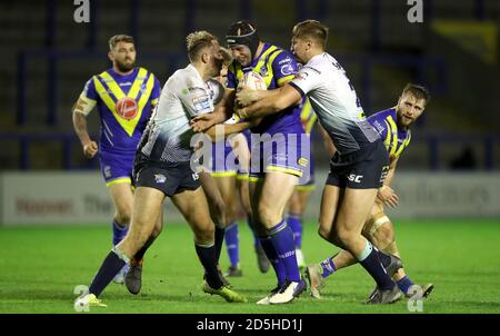 Le Chris Hill (au centre) de Warrington Wolves est abordé par Sam Walters (à gauche) de Leeds Rhinos et James Harrison lors du match de la Super League de Betfred au stade Halliwell Jones, à Warrington. Banque D'Images