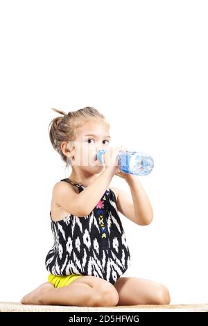 mignon litthe fille de l'eau potable d'une bouteille en plastique Banque D'Images