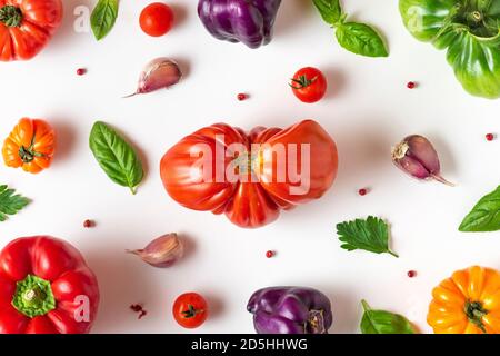 Cadre de légumes biologiques. Tomate, poivre, basilic, épices, ail. Nourriture de régime végétalien. Composition créative sur fond blanc. Concept de cuisine. Vue du dessus. Banque D'Images