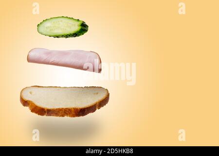 Lévitation sandwich au jambon et au concombre. Le concept de restauration rapide Banque D'Images