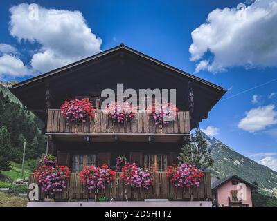 Belle maison de montagne en bois avec fleurs décoratives sur les balcons Banque D'Images