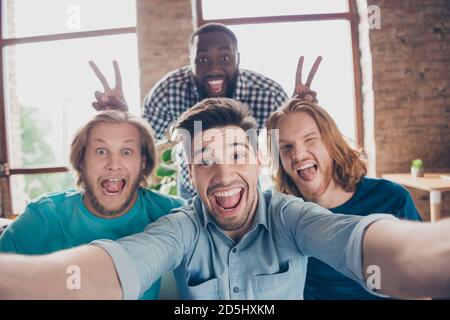 Portrait de l'homme positif réunion blogger profiter de temps libre faire selfie dupe grimace face aro american man show v-sign imaginaire oreilles de lapin dans la maison Banque D'Images