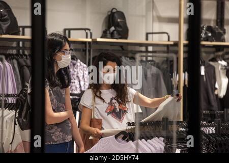 BELGRADE, SERBIE - 25 SEPTEMBRE 2020: Clients, femmes, regardant les tee-shirts dans un magasin de vêtements de détaillant de mode portant un masque respiratoire à Belg Banque D'Images