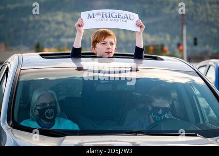 Kalispell, Montana, États-Unis. 11 octobre 2020. Un jeune homme porte un panneau pour Shane Morigeau, représentant de l'État auditeur au Montana Made Drive Out the vote Tour stop au champ de foire du comté de Flathead, dans un rassemblement de style Drive pour les candidats démocrates de l'État aux élections de 2020. Crédit : Kent Meireis/ZUMA Wire/Alay Live News Banque D'Images