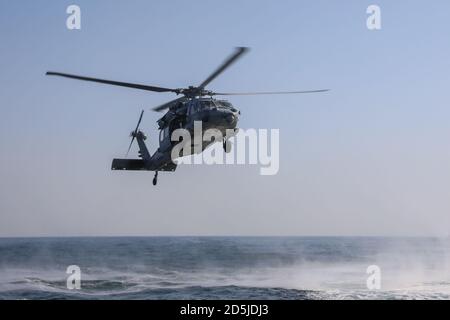 201011-A-RX269-1195 GOLFE PERSIQUE (OCT 11, 2020) - UN hélicoptère Seahawk MH-60S, attaché à l'escadron de combat en mer (HSC) 26, s'approche d'un patrouilleur Mark VI, non représenté, lors d'un exercice d'évacuation des blessés dans le golfe Arabo-Persique, le 11 octobre. HSC 26 est déployé dans la zone d'opérations de la 5e flotte des États-Unis à l'appui des opérations navales afin d'assurer la stabilité et la sécurité maritimes dans la région centrale, reliant la mer Méditerranée et l'océan Pacifique à travers l'océan Indien occidental et trois points d'étranglement stratégiques à la libre circulation du commerce mondial. (Photo de l'armée des États-Unis par le SPC. William Gore) Banque D'Images