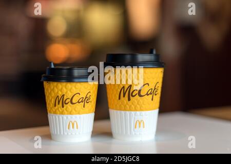 Kiev, Ukraine - 12 OCTOBRE 2020 : deux tasses de café en papier avec le logo McDonald's et McCafe sur la table près de la fenêtre sur le fond de McDonald's flou Banque D'Images