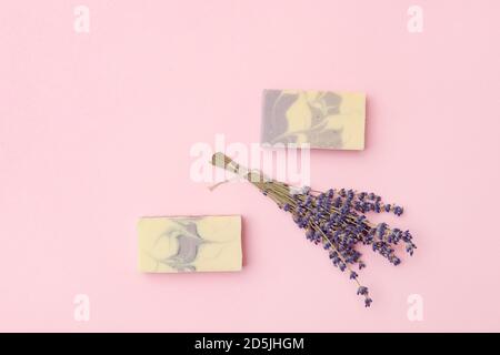 Savon naturel fait à la main avec lavande séchée et huile essentielle sur fond rose. Concept zéro déchet Banque D'Images