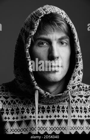 Beau homme portant un sweat à capuche sur fond gris Banque D'Images