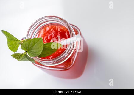 Smoothie au melon d'eau dans un pot avec des feuilles de menthe et un paille cocktail Banque D'Images