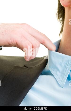 Un jeune homme en costume détache son col de chemise Banque D'Images