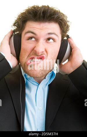 Jeune homme en costume avec casque faisant des visages Banque D'Images