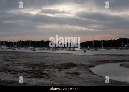 Coucher de soleil spectaculaire sombre sur la raffinerie de pétrole sur la côte sud de Hamshire, Angleterre à marée basse. Industrie yachts d'eau industrielle Banque D'Images