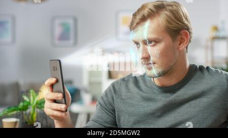 Jeune homme identifié par la reconnaissance faciale biométrique processus de lecture à partir de son smartphone. Concept futuriste : le projecteur identifie l'individu par Banque D'Images