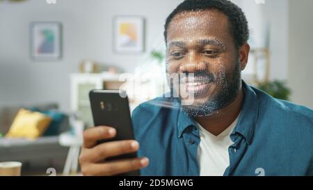 Jeune homme identifié par la reconnaissance faciale biométrique processus de lecture à partir de son smartphone. Concept futuriste : le projecteur identifie l'individu par Banque D'Images