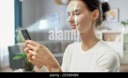 Jeune femme identifiée par la reconnaissance faciale biométrique processus de lecture à partir de son smartphone. Concept futuriste : le projecteur identifie l'individu par Banque D'Images