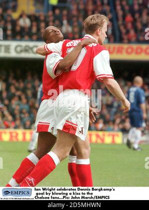 Ian Wright (à gauche) d'Arsenal célèbre le but de son coéquipier Dennis Bergkamp (à droite) en soufflant un baiser aux fans de Chelsea Banque D'Images