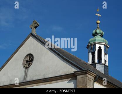 L'horloge frappe 12! Vieille église blanche avec croix et tour avec horloge d'or et un toit vert très spécial. Ailette d'étanchéité avec 1690 sur le dessus. Banque D'Images