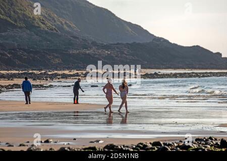 Langland Bay, Swansea, Royaume-Uni. 14 octobre 2020. Nageurs en mer ce matin, profitez au maximum du magnifique temps d'automne à Langland Bay près de Swansea. Comme d'autres régions du pays de Galles et du Royaume-Uni, Swansea est actuellement en confinement (à partir du 27 septembre 2020) suite à une forte augmentation des cas de coronavirus (COVID-19) dans la région du Conseil municipal de la ville et du comté de Swansea. Credit: Phil Rees/Alamy Live News Banque D'Images