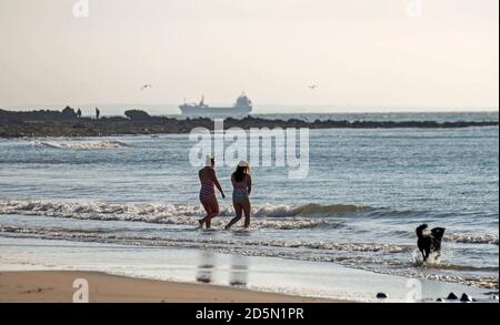 Langland Bay, Swansea, Royaume-Uni. 14 octobre 2020. Nageurs en mer ce matin, profitez au maximum du magnifique temps d'automne à Langland Bay près de Swansea. Comme d'autres régions du pays de Galles et du Royaume-Uni, Swansea est actuellement en confinement (à partir du 27 septembre 2020) suite à une forte augmentation des cas de coronavirus (COVID-19) dans la région du Conseil municipal de la ville et du comté de Swansea. Credit: Phil Rees/Alamy Live News Banque D'Images