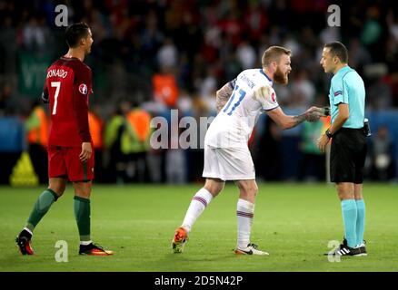 Aron Gunnarsson, de l'Islande, serre la main avec l'arbitre Cuneyt Cakir après Le jeu comme Cristiano Ronaldo (à gauche) du Portugal regarde sur Banque D'Images