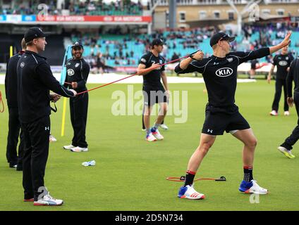 Le capitaine de Surrey Gareth Batty aide Thomas Curran (à droite) avec son préchauffage avant match Banque D'Images