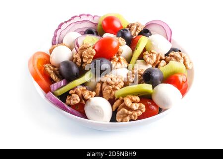 Salade avec tomates cerises, mozzarella, olives noires, kiwi et noix isolées sur fond blanc. Gros plan. Banque D'Images