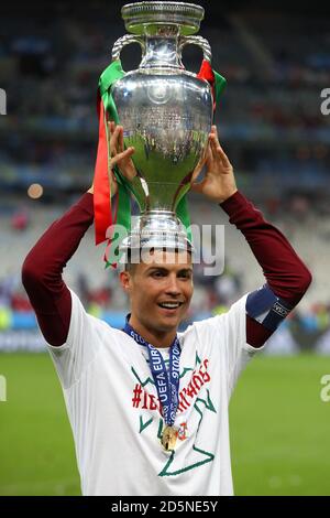 Cristiano Ronaldo du Portugal célèbre avec le trophée sur le terrain après que le Portugal a remporté la finale de l'UEFA Euro 2016. Banque D'Images