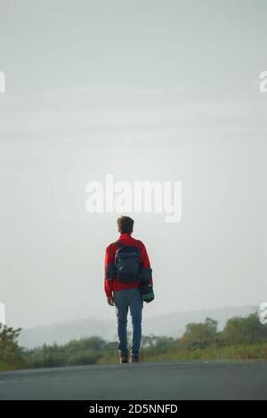 Backpacker marchant sur la route Banque D'Images