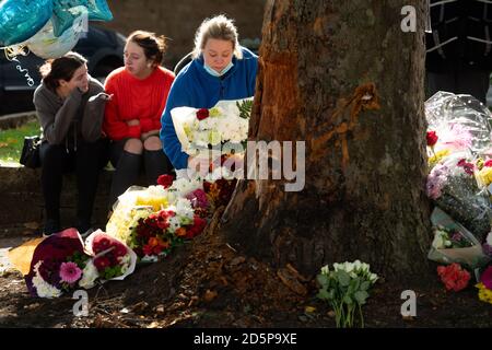 Une femme pose des fleurs sur le théâtre d'un accident mortel sur Bromley Lane à Kingswinford, près de Dudley, qui a tué trois personnes après l'accident de la voiture dans laquelle ils se trouvaient, dans un arbre, mardi soir. Deux adolescentes et un chauffeur dans ses années 20 ont été déclaré morts sur les lieux, tandis que deux autres, un adolescent et une adolescente voyageant également dans la Skoda Fabia jaune, sont dans un état critique à l'hôpital. Banque D'Images