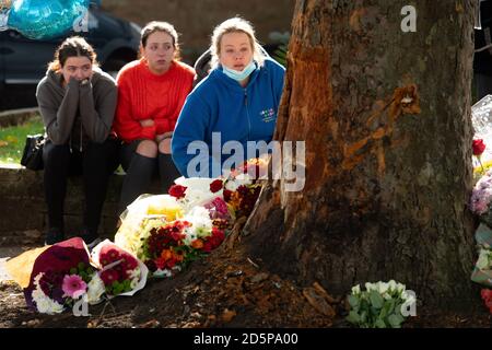 Une femme pose des fleurs sur le théâtre d'un accident mortel sur Bromley Lane à Kingswinford, près de Dudley, qui a tué trois personnes après l'accident de la voiture dans laquelle ils se trouvaient, dans un arbre, mardi soir. Deux adolescentes et un chauffeur dans ses années 20 ont été déclaré morts sur les lieux, tandis que deux autres, un adolescent et une adolescente voyageant également dans la Skoda Fabia jaune, sont dans un état critique à l'hôpital. Banque D'Images