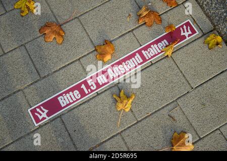 Laboe, Allemagne. 14 octobre 2020. Des feuilles de couleur automatique sont coulées à côté d'un autocollant avec l'inscription « Veuillez garder une distance de 1.5 m » sur le sol devant un restaurant de poissons. Avant la rencontre entre les gouvernements fédéral et les gouvernements des États, les politiciens de différents partis insistent sur une réglementation corona uniforme, claire et compréhensible pour accroître l'acceptation. Credit: Gregor Fischer/dpa/Alay Live News Banque D'Images