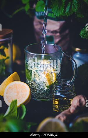 Thé chaud avec citron et menthe dans une tasse de verre Banque D'Images