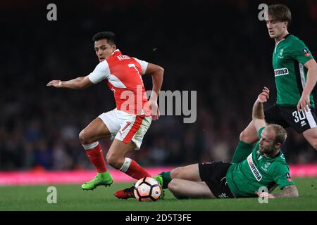 Alexis Sanchez d'Arsenal (à gauche) passe devant Bradley Wood de Lincoln City avant marque le quatrième but de son côté du jeu Banque D'Images