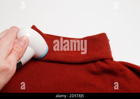 Dispositif d'élimination des peluches des vêtements en laine. Golf avec boule de fuzz isolée sur fond blanc. Banque D'Images