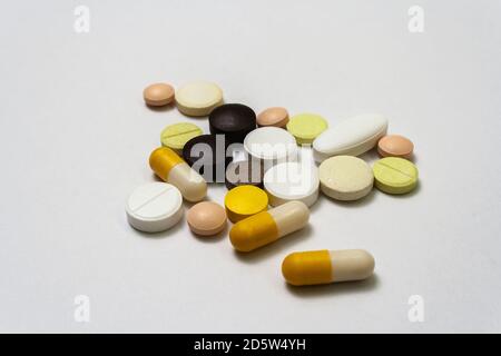 Bouquet de pilules et capsules colorées sur un fond blanc gros plan, macroshot comprimés, isolé. Médicaments en cas de pandémie. Médicaments traitement de la maladie - Covid-1 Banque D'Images