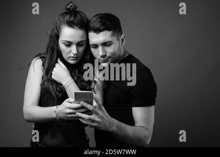 Jeune couple ensemble et amoureux sur fond gris Banque D'Images